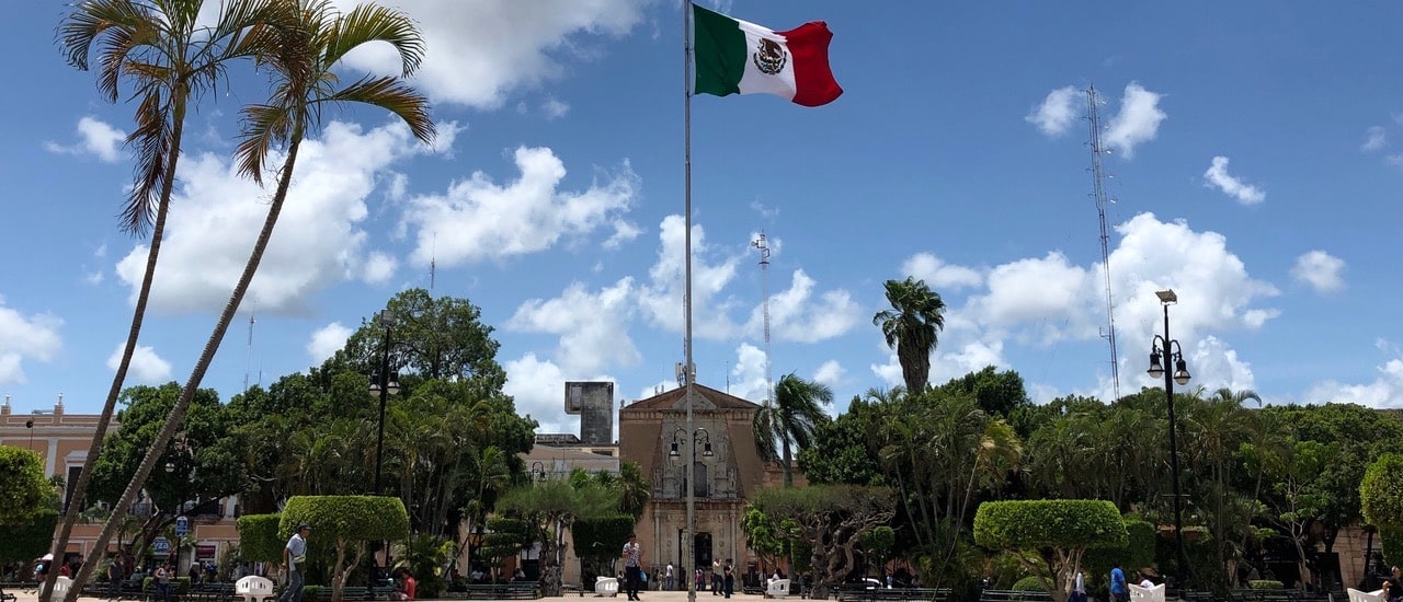 a park in front of the building with the mexican flag in the center